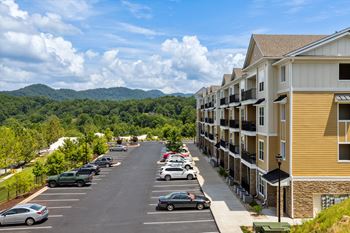 a city street with cars parked in front of a large apartment building